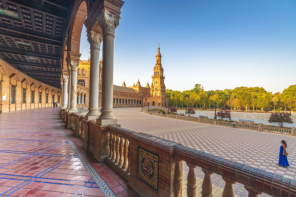 Sunrise on the old tower seen from colonnade of the semi-circular portico, Plaza de Espana, Seville, Andalusia, Spain, Europe