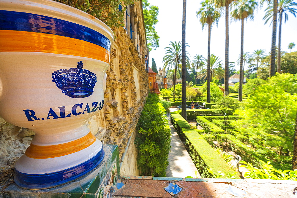 Decorated ceramic pot with royal symbol of crown on balustrade facing the lush gardens, Real Alcazar, UNESCO World Heritage Site, Seville, Andalusia, Spain, Europe