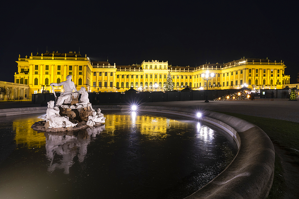 Marble statues of the Naiad Fountain in front of the illuminated Schonbrunn Palace, UNESCO World Heritage Site, Vienna, Austria, Europe