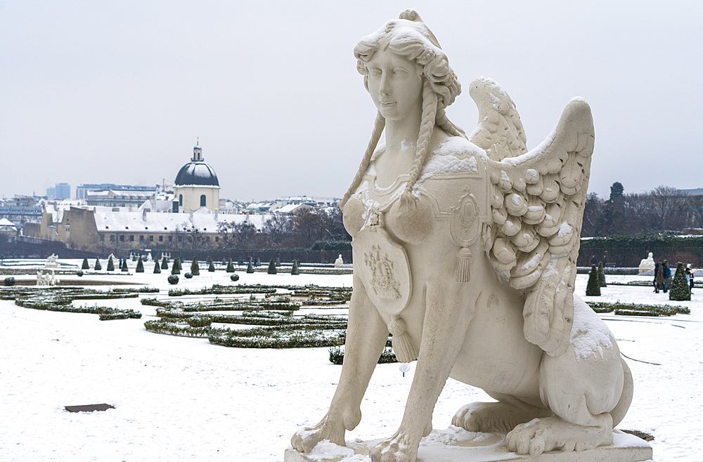 Mythological statue in the snow covered Belvedere Garten, gardens of castle housing an art museum, Vienna, Austria, Europe