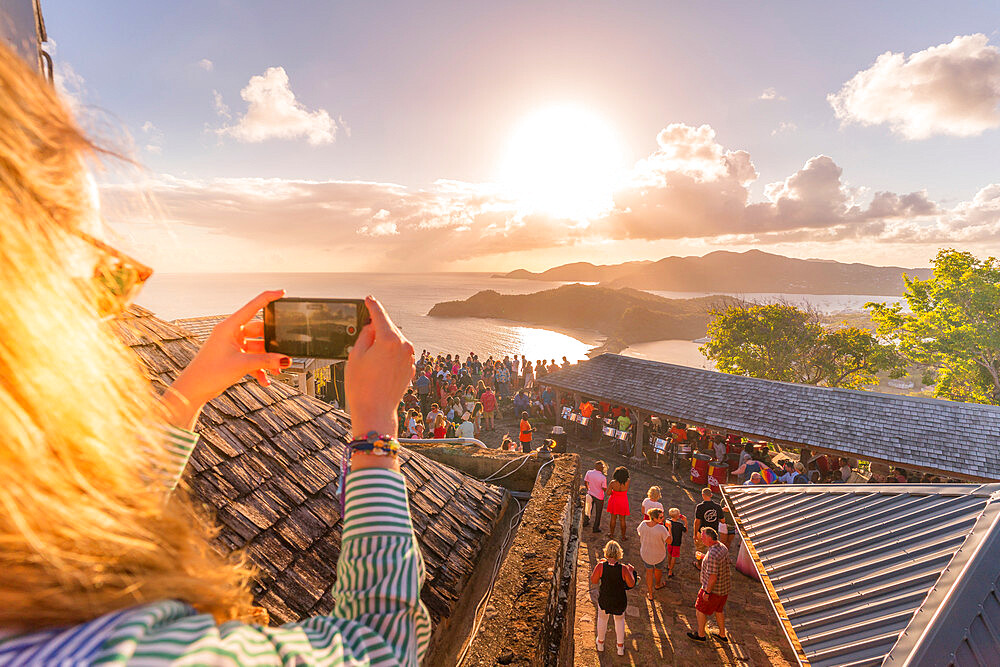 Woman takes pictures with smartphone during sunset party, Shirley Heights, Antigua, Antigua and Barbuda, West Indies, Caribbean, Central America