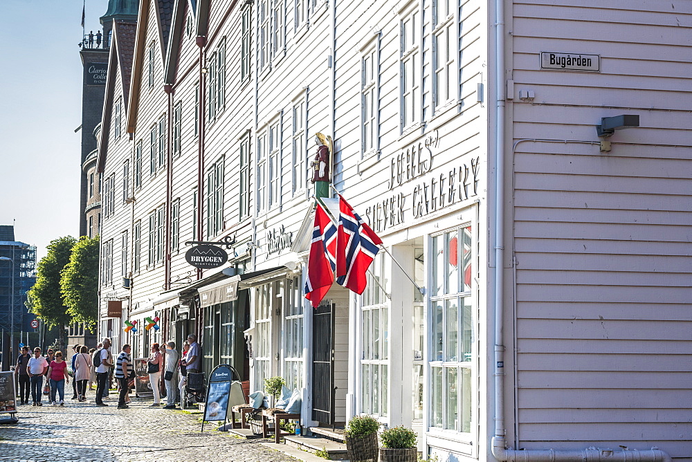 Tourists look at shops and traditional wood buildings in Bryggen old street, Bergen, Hordaland County, Norway, Scandinavia, Europe