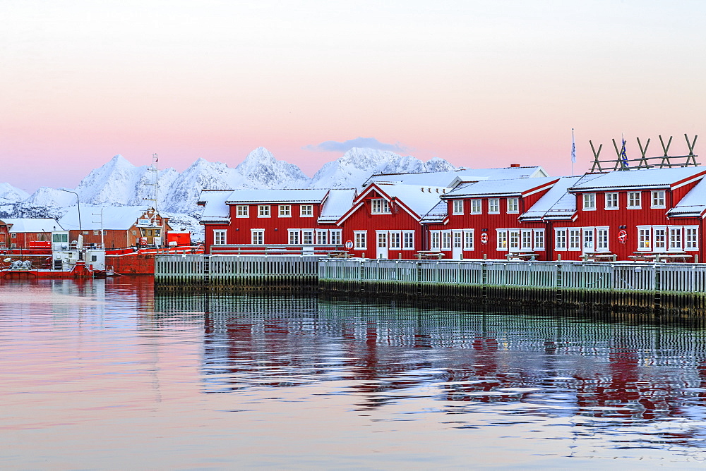 Pink sunset over the typical red houses reflected in the sea, Svolvaer, Lofoten Islands, Norway, Arctic, Scandinavia, Europe