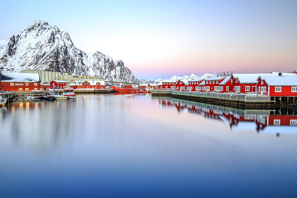 Pink sunset over the typical red houses reflected in the sea, Svolvaer, Lofoten Islands, Norway, Arctic, Scandinavia, Europe