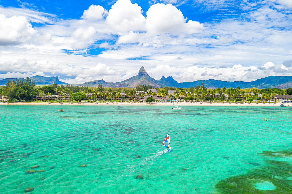 Aerial view by drone of windsurfer in the lagoon facing Flic en Flac beach and Piton de la Petite Riviere Noire mountain, Black River, Mauritius, Indian Ocean, Africa