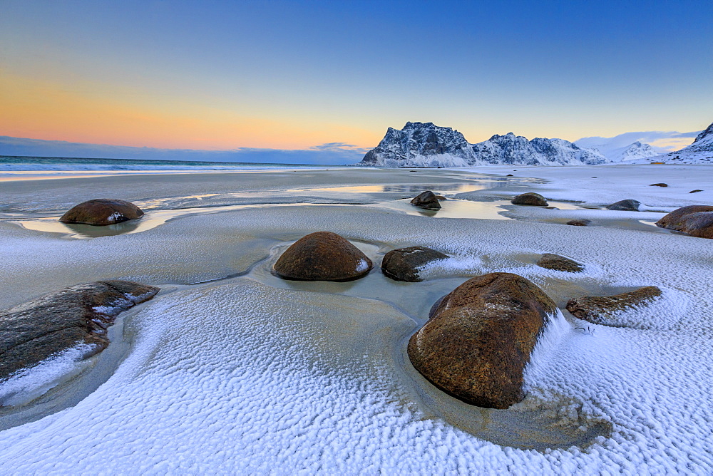 Dawn illuminates the rocks shaped by wind surrounded by fresh snow, Uttakleiv, Lofoten Islands, Arctic, Norway, Scandinavia, Europe