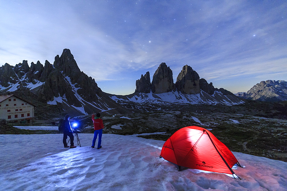 Hikers admire the Three Peaks of Lavaredo before spending the night in the tent, Sesto, Dolomites, Trentino-Alto Adige, Italy, Europe