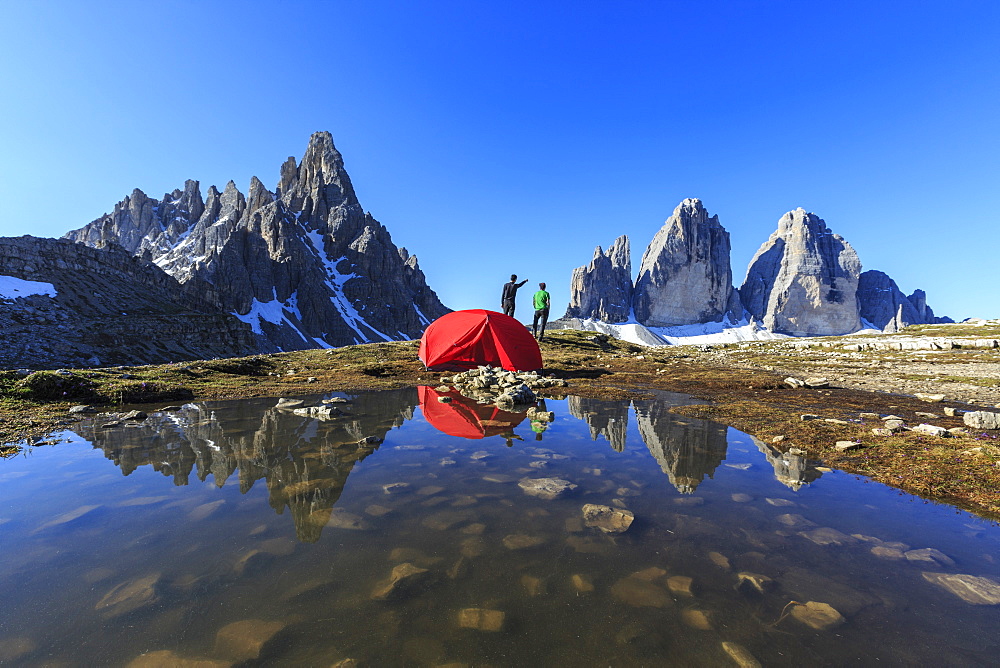 Hikers camped for the night admire the Three Peaks of Lavaredo on awakening, Sesto, Dolomites, Trentino-Alto Adige, Italy, Europe