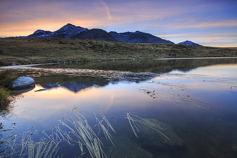 Pink sky on Peak Emet reflected in Lake Andossi at dawn, Chiavenna Valley, Spluga Valley, Valtellina, Lombardy, Italy, Europe