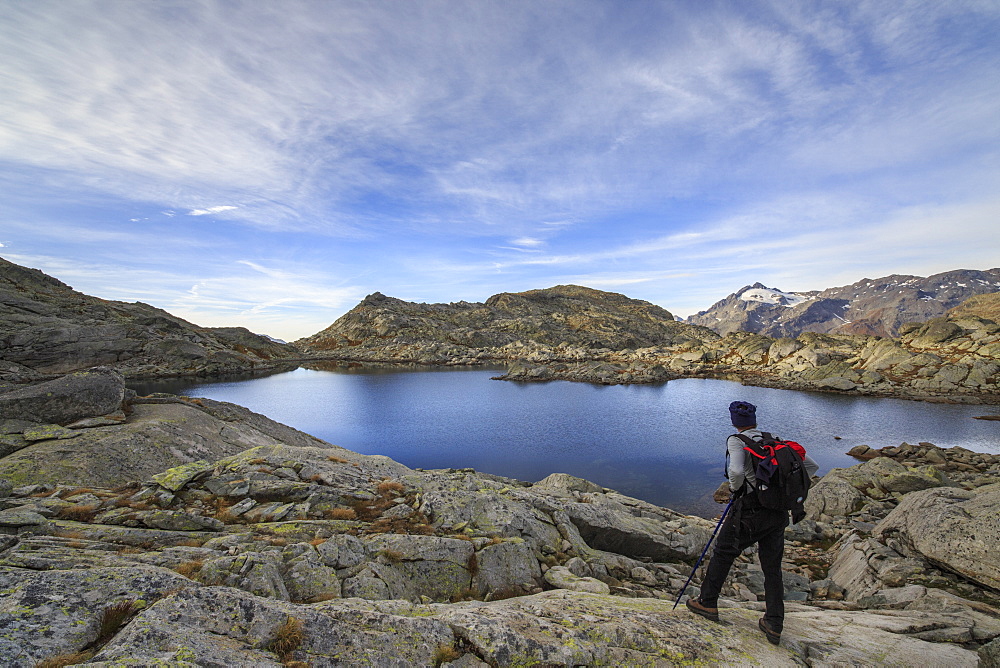 Hiker admires Laghi Azzurri at sunrise, Chiavenna Valley, Spluga Valley, Valtellina, Lombardy, Italy, Europe