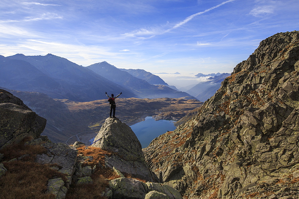 Hiker admires Lake Montespluga from Pizzo Della Casa, Chiavenna Valley, Spluga Valley, Valtellina, Lombardy, Italy, Europe