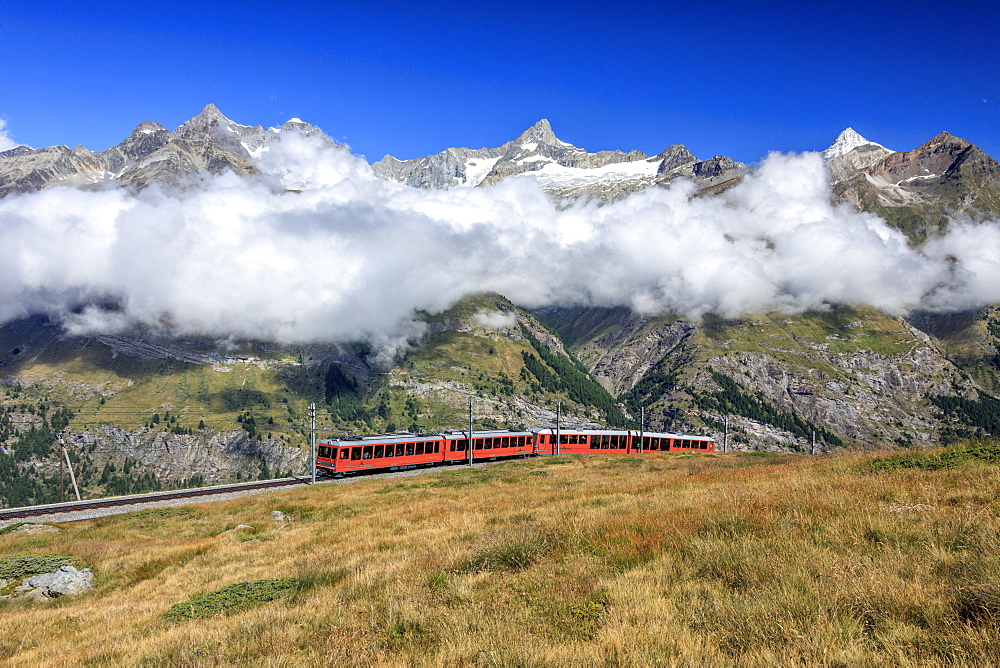 The Bahn train on its route with high peaks and mountain range in the background, Gornergrat, Canton of Valais, Swiss Alps, Switzerland, Europe