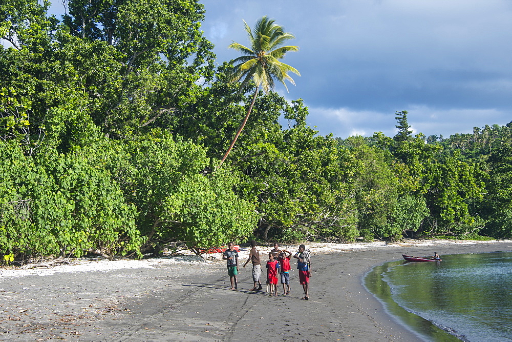 Local boys walking on a pretty black sand volcanic beach, Epi Island, Shepherd Islands, Vanuatu, Pacific