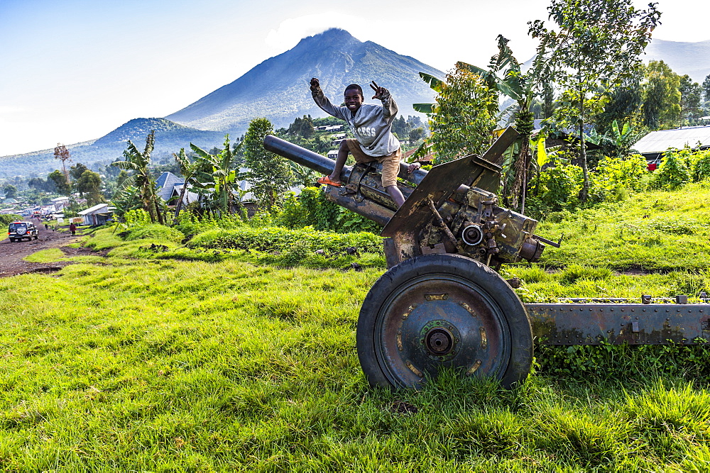 Boys posing on abandoned artillery in the Virunga National Park, Democratic Republic of the Congo, Africa