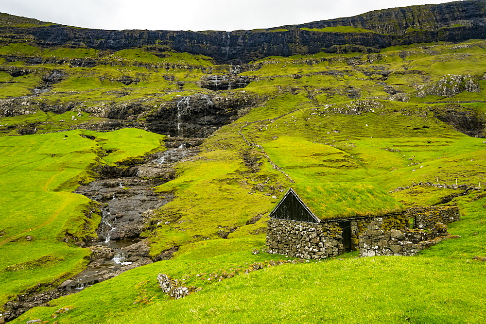 Grasstop roof house before a waterfall, Saksun, Streymoy, Faroe Islands, Denmark, Europe