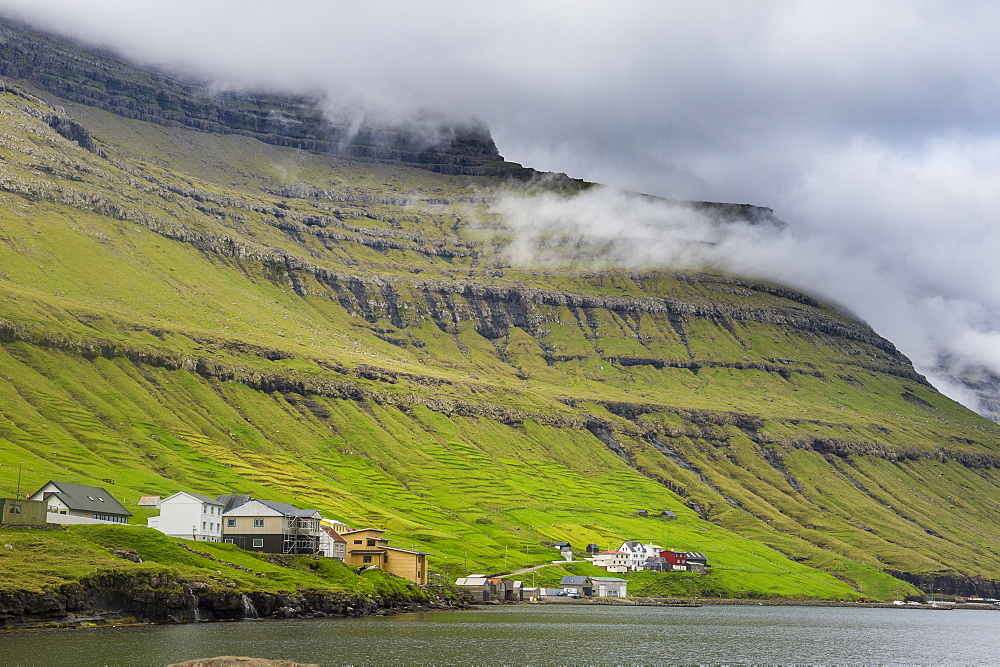 Little village below the cliffs of Kunoy, Faroe Islands, Denmark, Europe