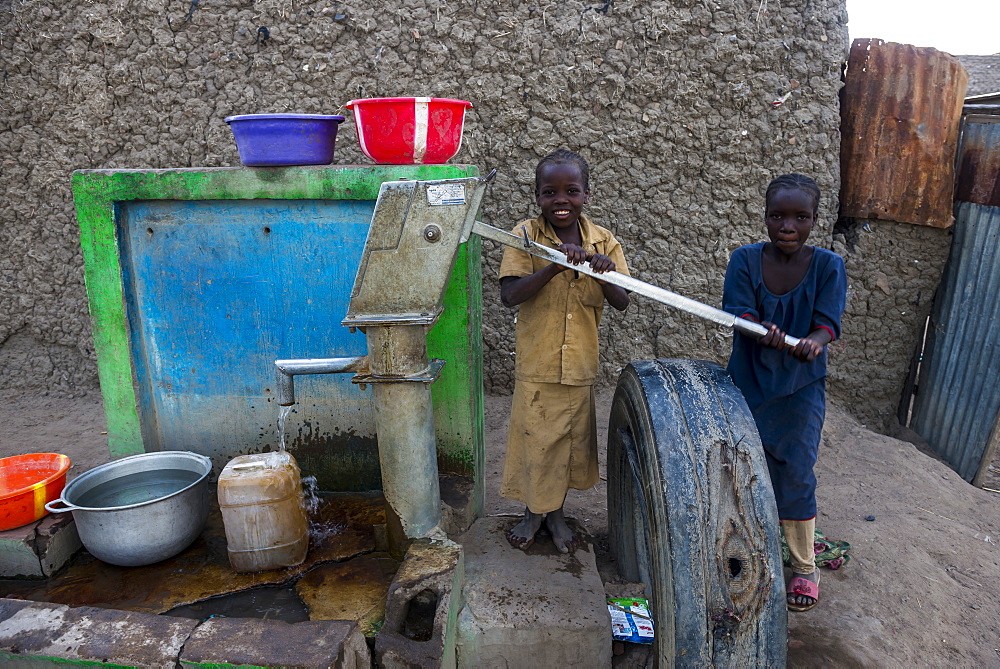 Local kids on a water well, Gaoui, near N'Djamena, Chad, West Africa, Africa