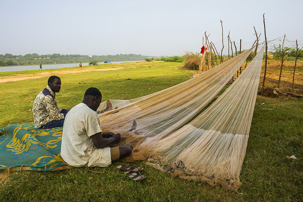 Fishermen repairing their fishing nets on the River Niger, Niamey, Niger, Africa