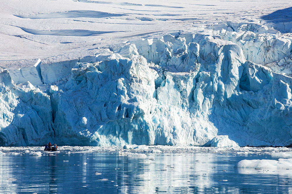 Zodiac with tourists cruising in front of a huge glacier, Hope Bay, Antarctica, Polar Regions