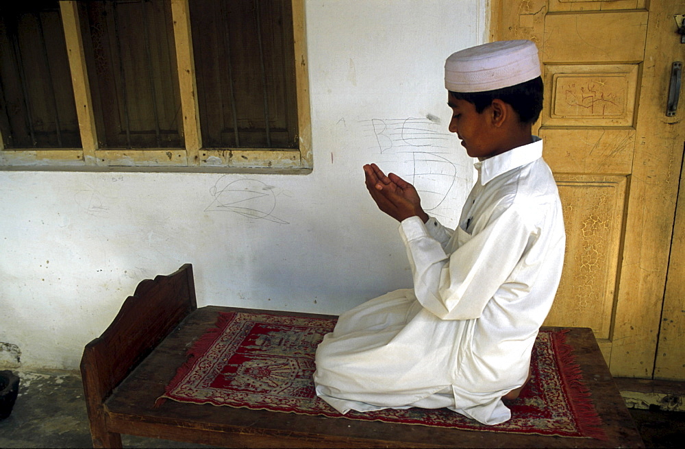 Religion, pakistan. Boy praying in his village at dawn