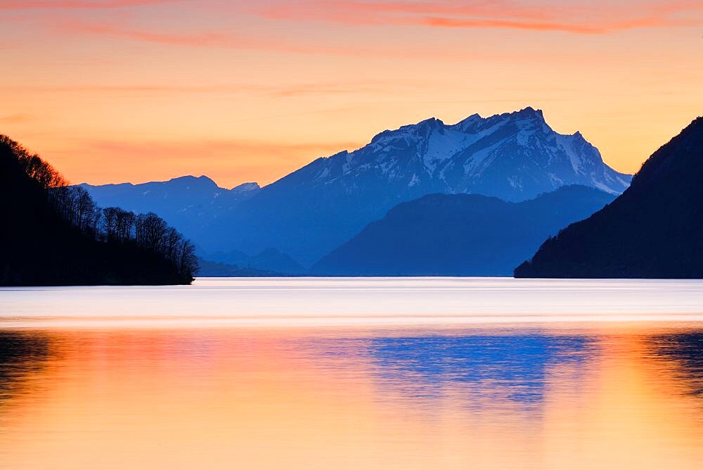 Calm waters of Lake Lucerne at dusk with Mount Pilatus in the background, Kanton Schwyz, Switzerland