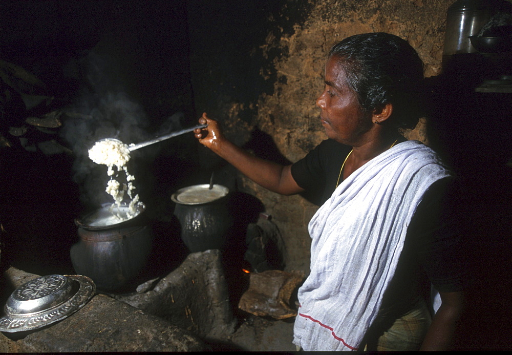 India - women - labor: woman cooking rice, pinkulam, kerala