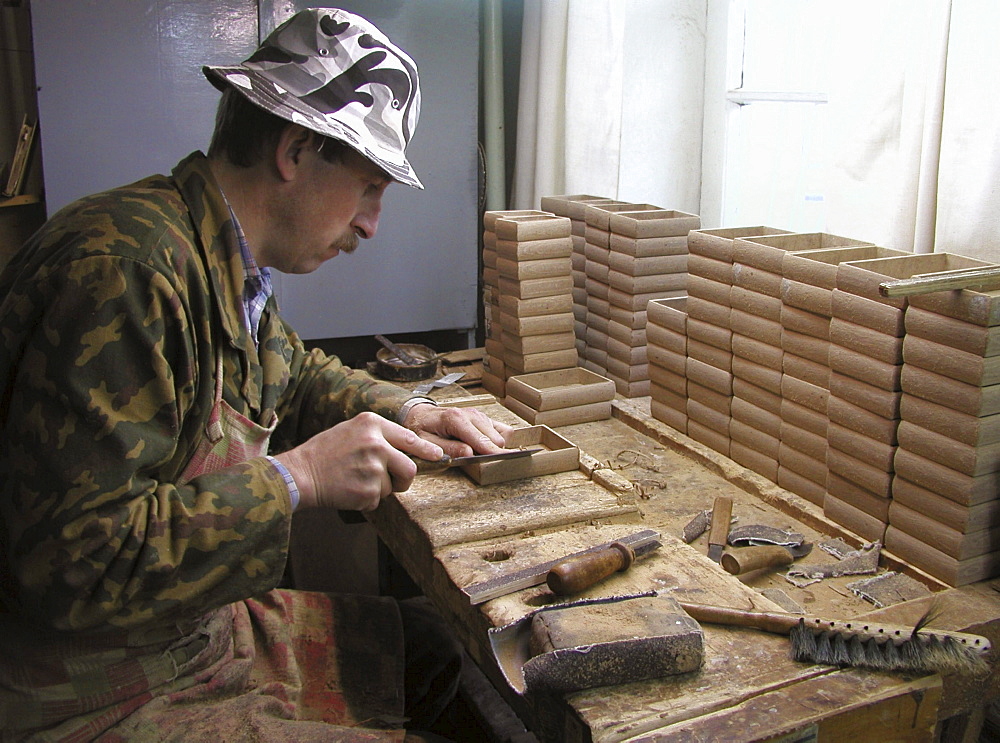 Russia man making papier mache boxes on which miniatures be painted palekh