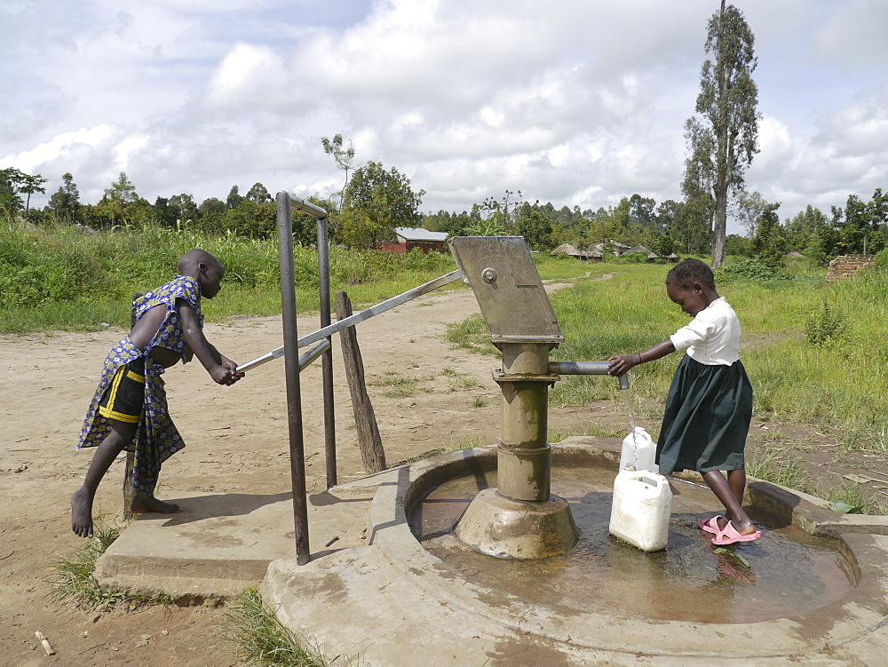 UGANDA Children collecting water from hand-pumped bore well, Gulu. PHOTO by Sean Sprague