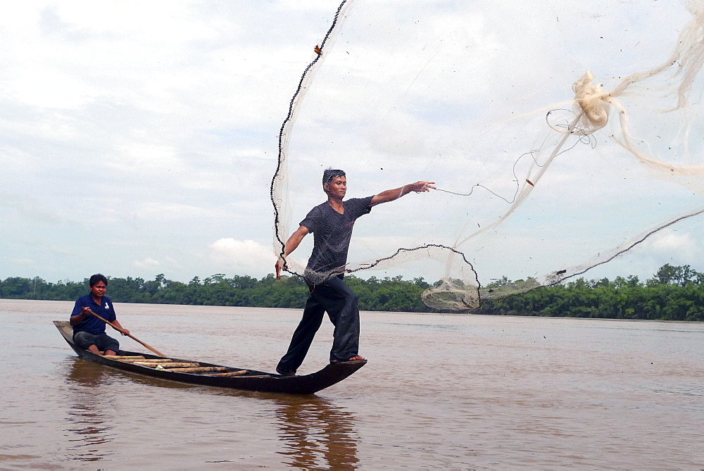 CAMBODIA Sovat Komsonath (29) fishing in the Sekong River, Ban Bung village, Stung Treng district. In this image he is casting his net