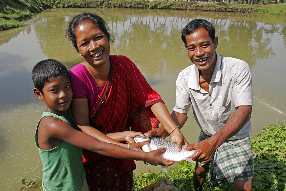 Bangladesh family with fish caught in their pond garo tribal minority haluaghat, mymensingh region