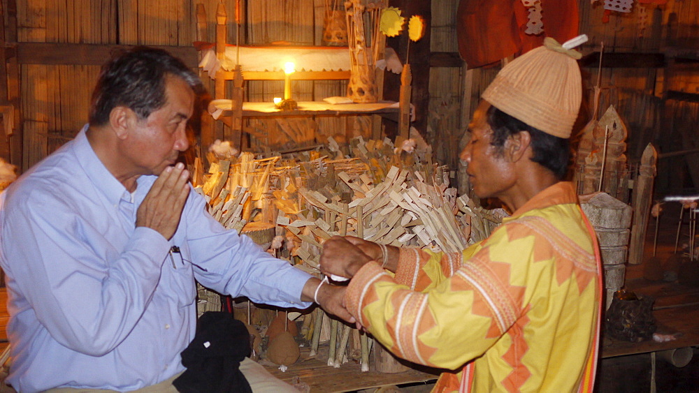 THAILAND Visit to Ban Pan Tong, a Lahu village which practices traditional religion. The local 'tobo' or shaman at the village chapel shrine conducting Animist ceremony. Photo by Sean Sprague