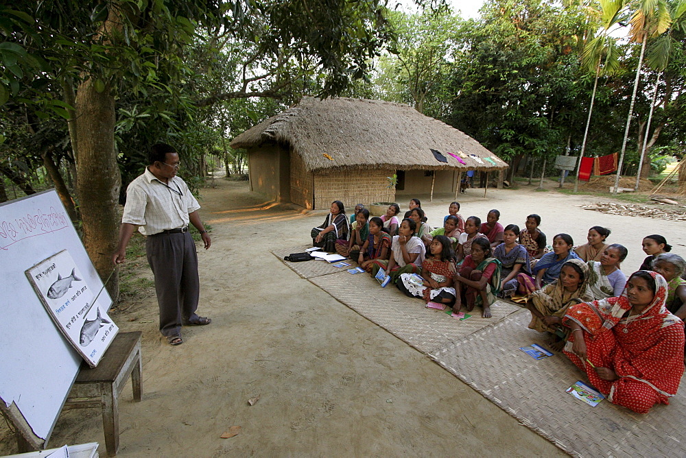 Bangladesh a group of women of the garo tribal minority attend a session of instruction about fish farming from a specialist at haluaghat, mymensingh region