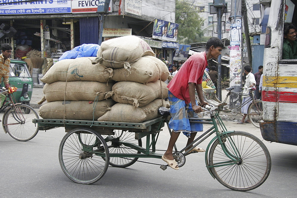 Bangladeshmany carrying heavy load on bicycle cart.Dhaka