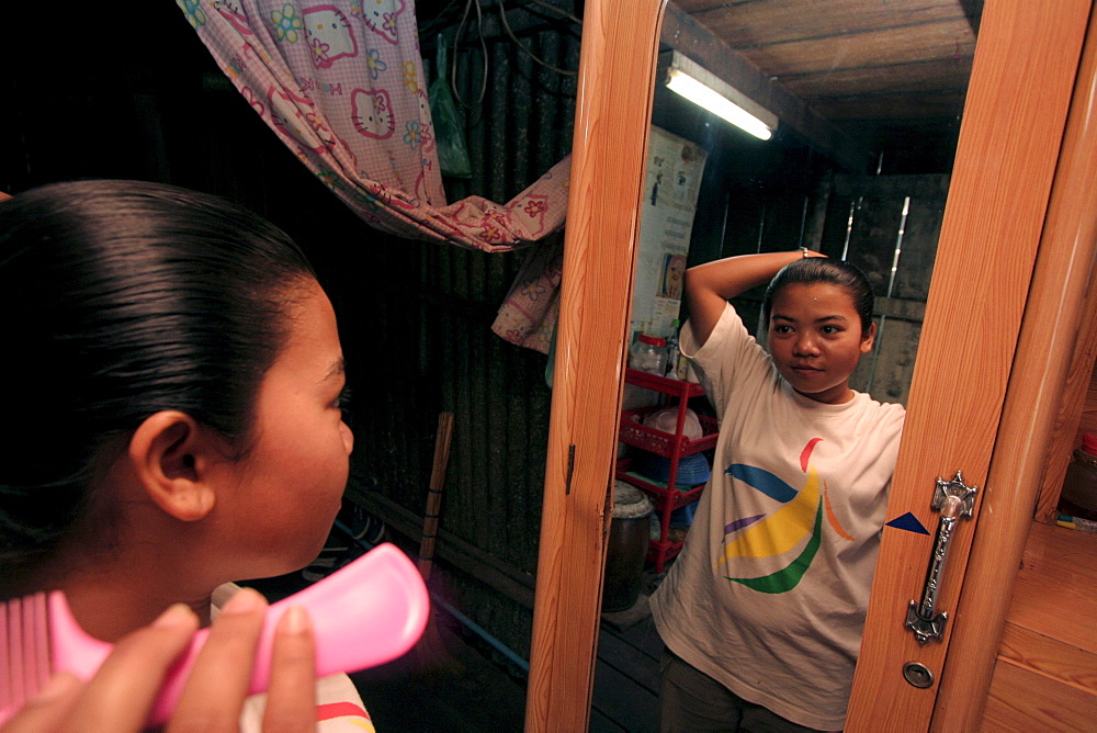 Cambodia girl brushing hair, phnom penh.