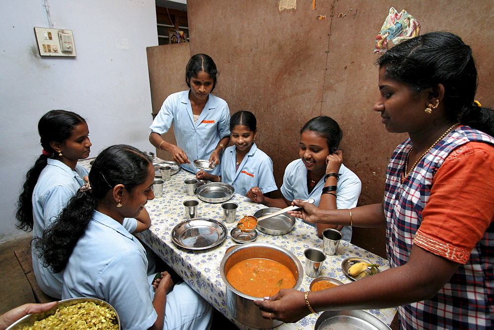 India queens garments, a project for poor women run by the congregation of the mother of carmel (cmc) sisters, kottayam, kerala. The young women serving and eating lunch, which they prepare themselves.