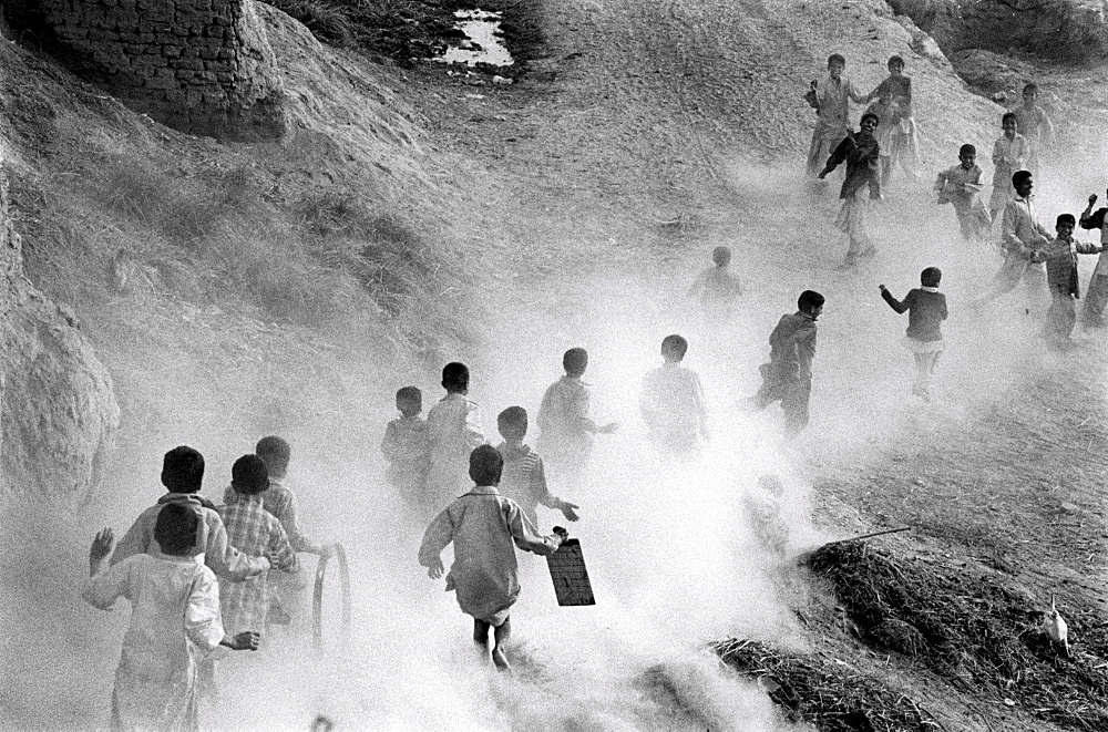 Landscape boys raising dust as they home from school. A village in punjab, pakista