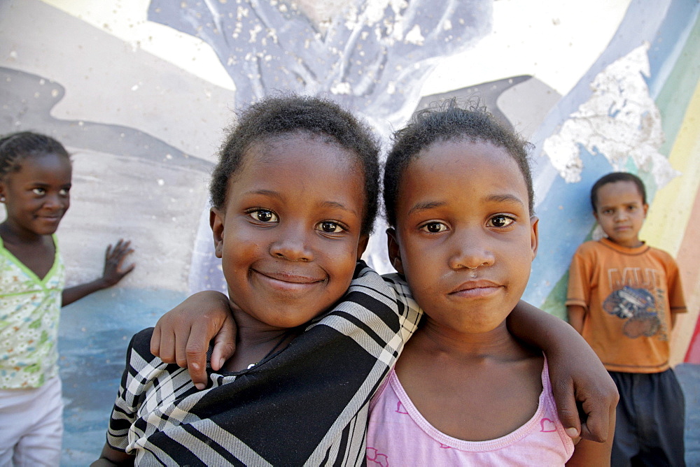 Namibia child at bernard nordkamp (youth) center, katatura, a black township of windhoek, dating from apartheid. country very high rates, mural behind depicts struggle against aids