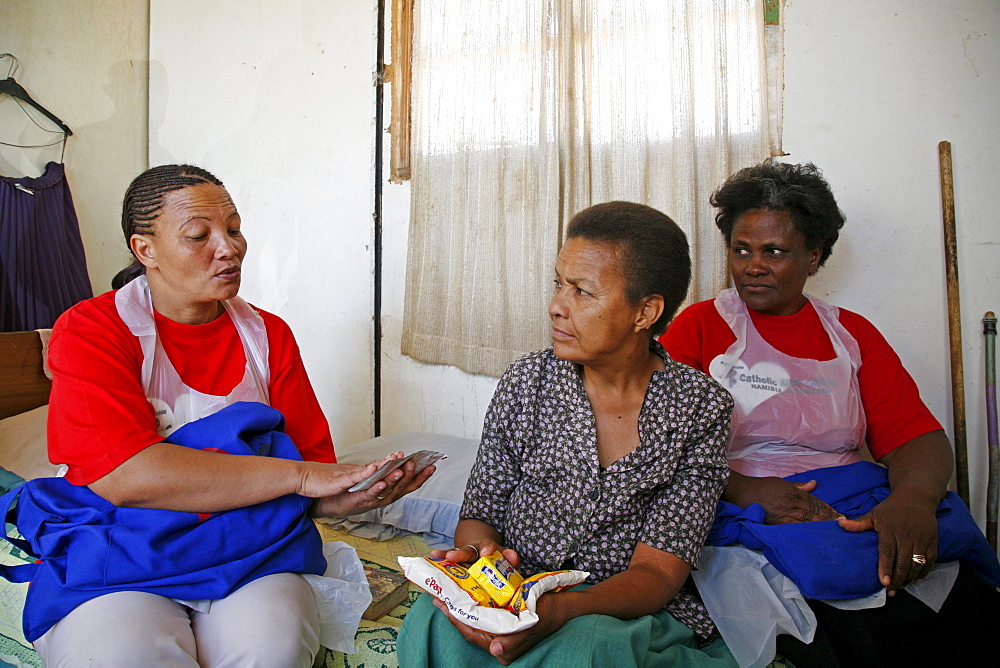 Namibia voluntary home visitors catholic aids action visiting a sick woman with at home in rehobeth. They provide with arvs (anti retro viral) medicines which made in india