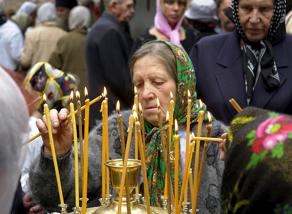 Russia lighting candles at pechersky caves monastery, pskov district, founded on august 28th 1473 by saint jonah sheshnik