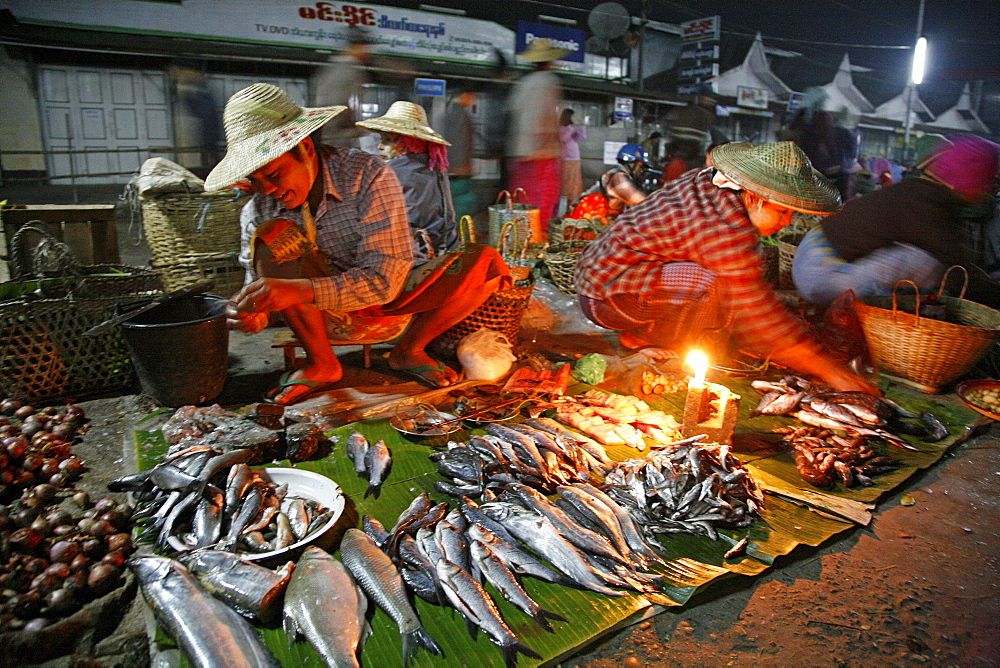 Myanmar traders selling fish with candle stalls at night market at myitkyina, a largely kachin community in north burma near chinese border 