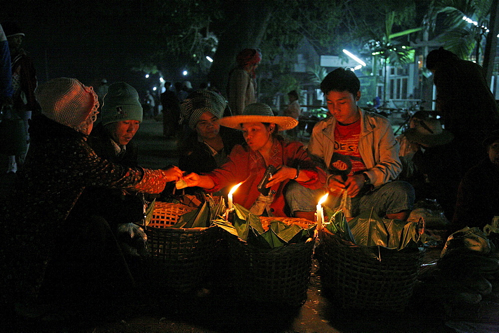 Myanmar traders selling food from candle stalls at night market at myitkyina, a largely kachin community in north burma near chinese border 