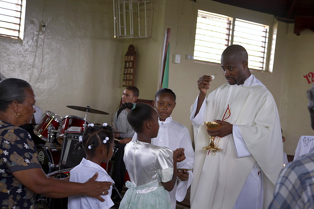 Jamaica. Communion given by father carl clark at sunday mass in the catholic church at seaford town