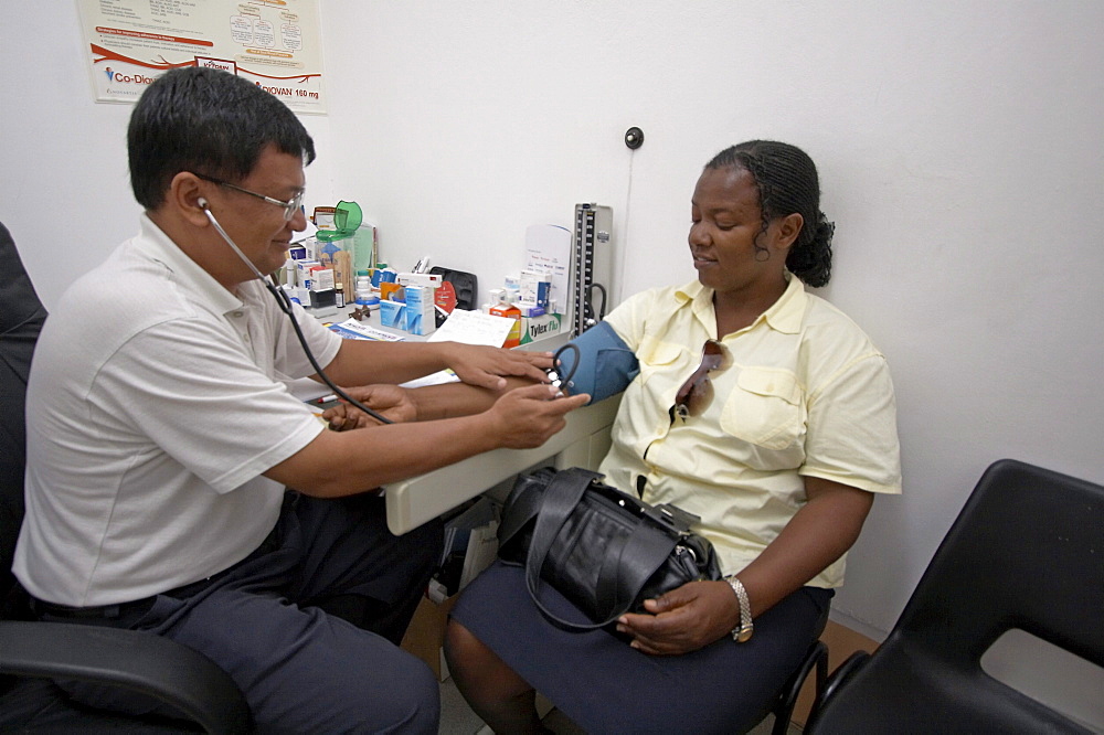 Jamaica. Doctor taking blood pressure in clinic at montego bay