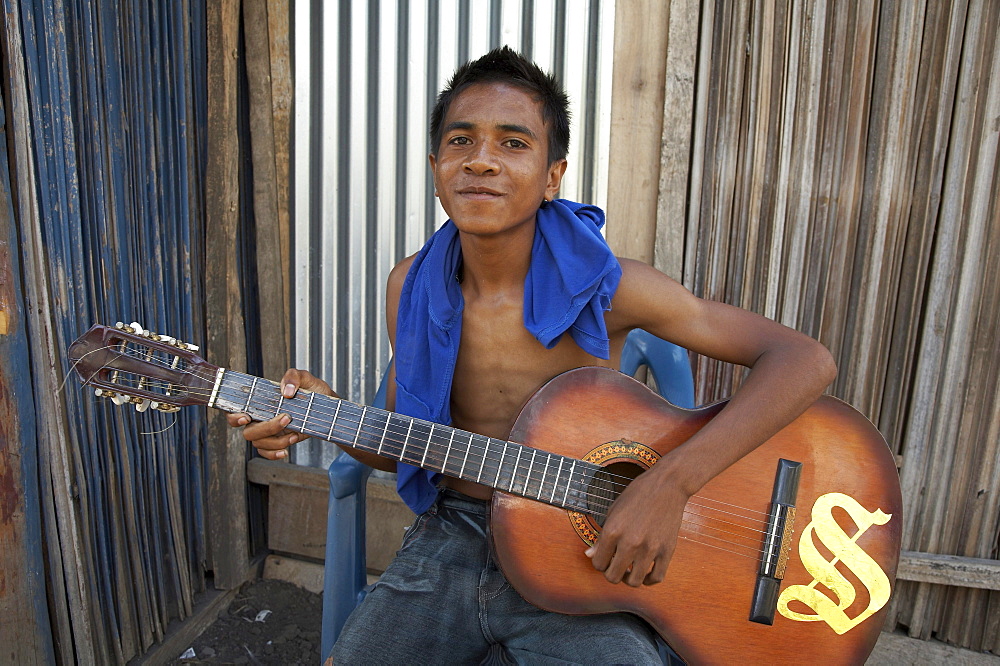 East timor. Boy playing guitar, topu honis orphanage and childrens home, oecussi-ambeno