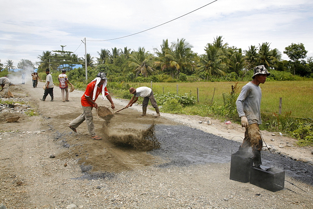 Indonesia workers asphalting a road which was constructed by a crs cash for work project, meulaboh, aceh, after the tsunami