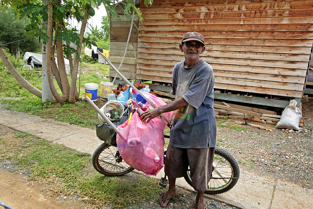 Indonesia mohammed sofyan yusuf, a garbage recycler and crs new house beneficiary, sorting recycables, monikeun, a suburb of banda aceh, aceh, two years after the tsunami