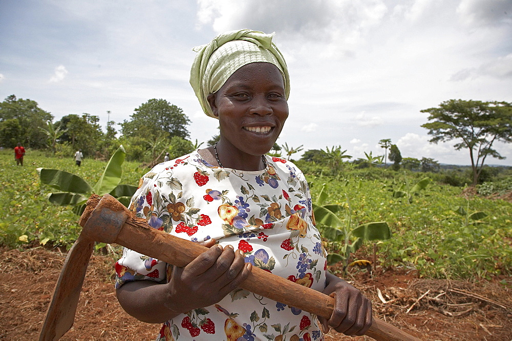 Uganda nejjemba teopista, farmer of kayunga and farmers group animator, holding her hoe after working in a communal garden at kangulumira where food is grown to feed the poor and sick. caritas uganda project