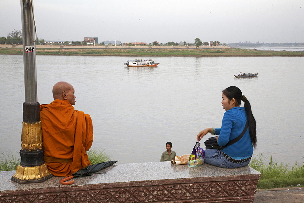 Cambodia scene along mekong river waterfront on a sunday, phnom penh. buddhist monk and woman