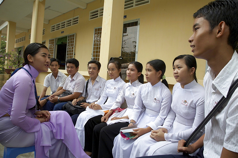 Vietnam anti trafficking project at tra on in vinh long province in the mekong delta region of vietnam. many young people have succumbed to bein.  for marriage or work in neighboring countries, and this project addresses the problem. in this image the vice-principal of tra on high school, ngoc bich, talks to a group of 12th graders about the problem