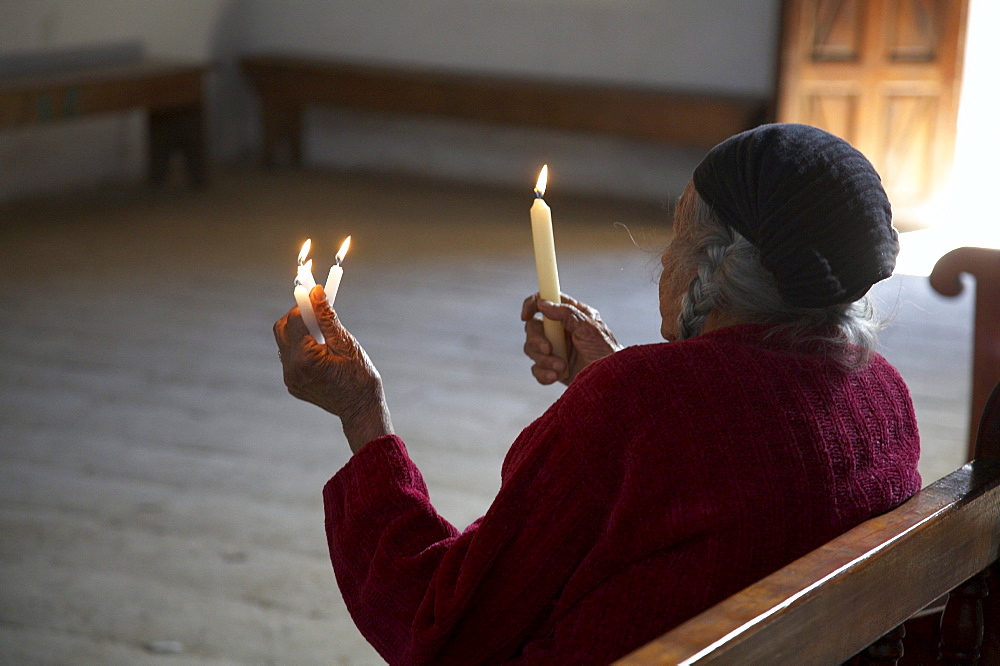 Guatemala woman holding candles in church of chajul, el quiche